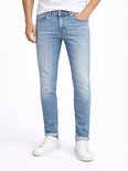 Lichtblauwe spijkerbroek, slank gesneden, met een stonewashed look. Een man draagt de broek met een wit T-shirt en witte sneakers.