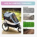 Hondenbuggy op verschillende ondergronden: verharde weg, oneffen weg, gras en onverharde weg.