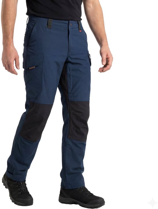 Homme en pantalon de randonnée bleu foncé avec genouillères noires et chaussures noires.
