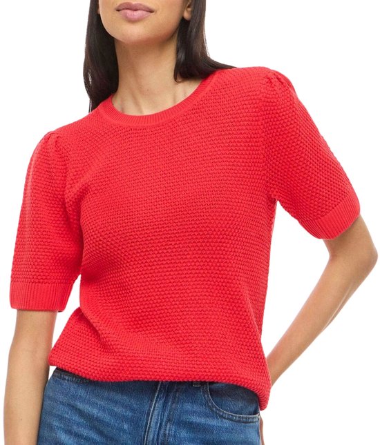 Top tricot rouge à manches courtes bouffantes, porté avec un jean.