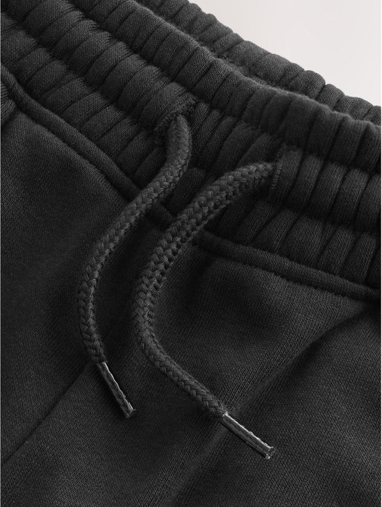 Close-up van de zwart gebreide stof met trekkoord van een joggingbroek.