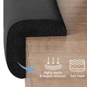 Zwarte hoekbeschermer van zacht schuim op een houten tafel, met iconen voor zacht schuim en elasticiteit.