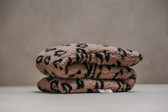 Een stapel teddy stoffen warmtekussens met panterprint in beige en zwart. Het kussen heeft een zachte, pluizige textuur.