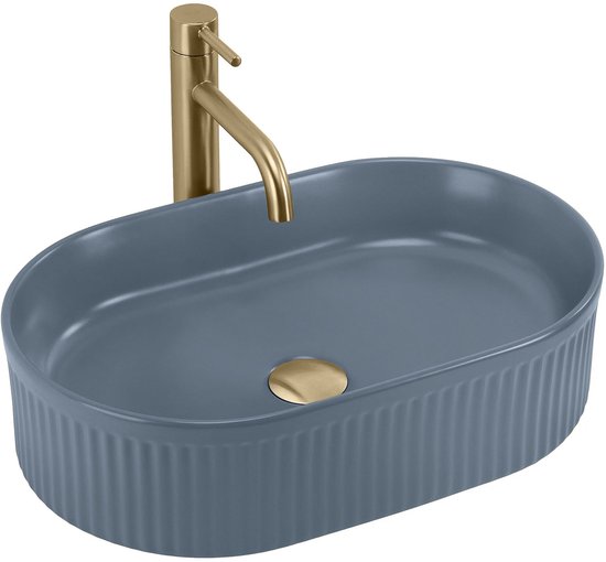 Blauwe, ovale opzetwastafel met verticale ribbels en een gouden kraan.