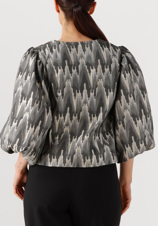 Achterkant blouse met volumineuze mouwen en een zigzag patroon in grijs, wit en zwart.