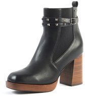 Zwarte leren laars met studs op enkelband, gesp, bruine houten plateauzool en blokhak.