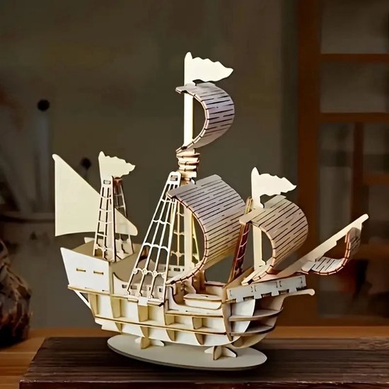Houten modelbouw zeilschip op een donkere ondergrond, met gedetailleerde masten, zeilen en vlaggen.