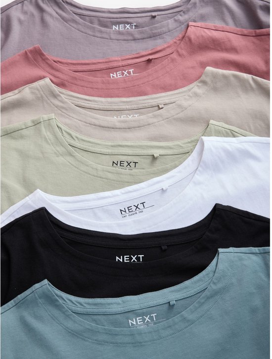 Close-up van de ronde halzen en neklabels van gestapelde T-shirts in verschillende kleuren: zwart, wit, beige, lichtgroen, oudroze en grijs.
