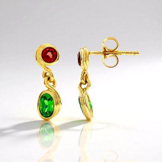 Boucles d'oreilles en or avec une grenat rouge ronde au-dessus d'une tsavorite verte ovale. Les boucles d'oreilles ont des clous dorés avec une tige d'oreille torsadée élégante.