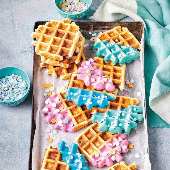 Wafels met roze en blauwe glazuur, bestrooid met kleurrijke hagelslag.