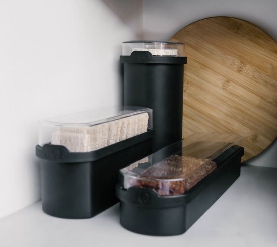 Trois boîtes de conservation noires avec couvercles transparents, remplies de biscottes, de pain d'épices et avec encore plus de biscottes sur le dessus de la boîte haute.