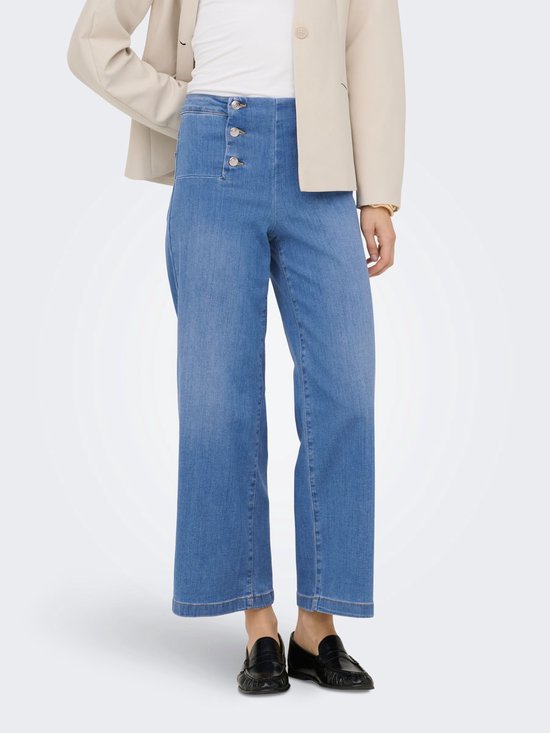 Model draagt wijde, blauwe denim jeans met hoge taille en dubbele knoopsluiting, met beige blazer.