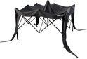 Een antracietkleurige partytent waarvan het dak los hangt en de zijkanten op de grond vallen, op een zwarte achtergrond.