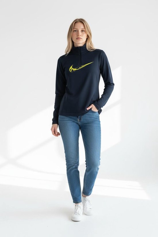 Donkerblauw sportvest met lange mouwen en grote gele Nike 'swoosh' op de voorkant. Gedragen door een model met spijkerbroek.