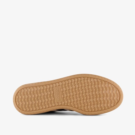 Onderkant van een beige Adidas sneaker met gumkleurige zool met Adidas logo en visgraatpatroon.