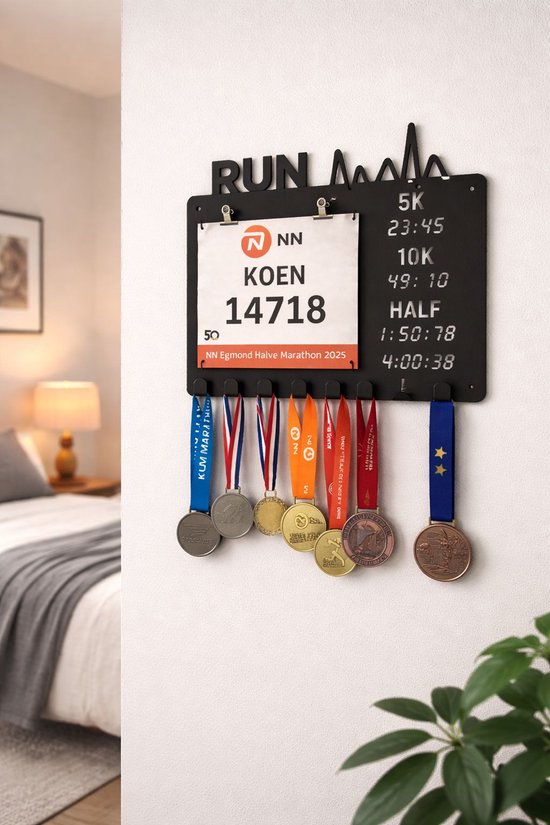 Zwarte medaillehouder met 'RUN' tekst, startnummer 'KOEN 14718' en diverse medailles aan linten, hangend aan een muur.