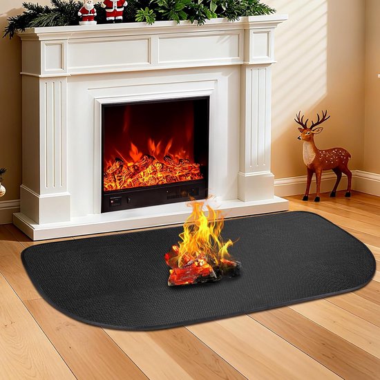 Zwarte mat voor een haard met brandend hout erop, naast een kerstboom.