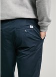 Close-up van de achterzak van een donkerblauwe chino met Pepe Jeans-label.