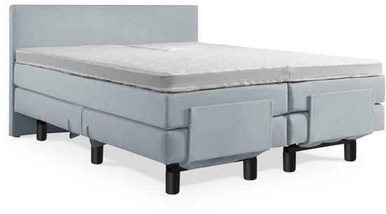 Elektrische boxspring in lichtblauw met een glad hoofdbord en matras. Zwart metalen poten.