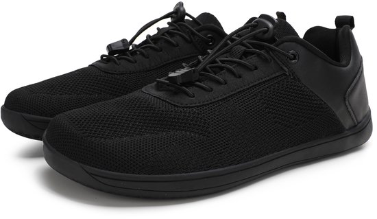 Paar zwarte lage sneakers met mesh bovenwerk en leren accenten.