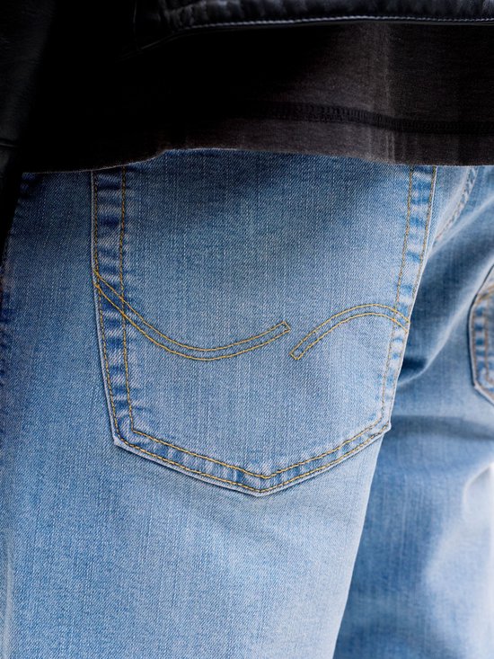 Close-up van de achterzak van een lichtblauwe jeans met decoratieve stiksels.