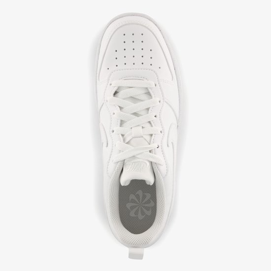 Bovenkant van een witte Nike sneaker met vetersluiting en een bloemvormig logo op de binnenzool.