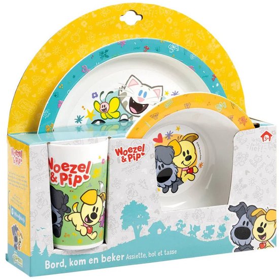Kinderservies met Woezel & Pip-personages: een bord, kom en beker met afbeeldingen van honden, een kat en een vlinder op een gele en blauwe achtergrond.