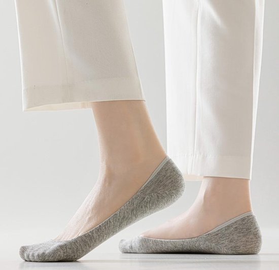 Grijze onzichtbare sokken gedragen met een witte broek.