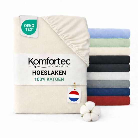 Een opgevouwen crème hoeslaken met een stapel hoeslakens in verschillende kleuren ernaast.