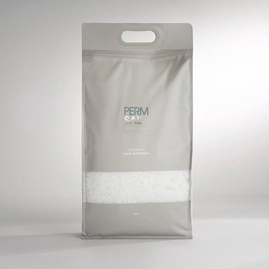 Grijze zak met 'PERMSAL magnesium bad kristallen' en 5kg vermelding. Bevat witte kristallen.