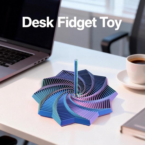 Multicolor metalen draaitol op een bureau naast een laptop en kopje koffie. Het speelgoed is een 3D-kunstwerk van op elkaar gestapelde zeshoeken.