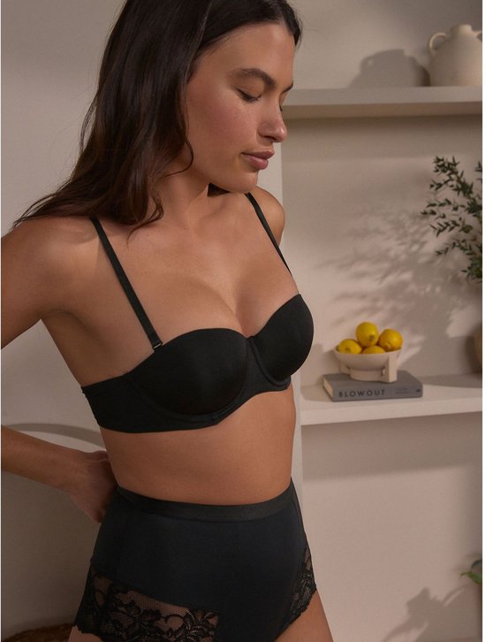 Model draagt zwarte push-up beha zonder bandjes en hoge taille broekje met kanten details.