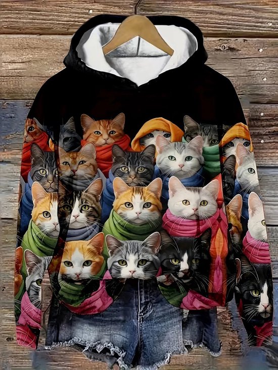 Zwarte hoodie met een print van veel katten met kleurrijke sjaals, gedragen op een jeansbroek.