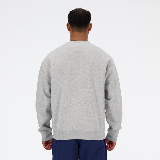 Achterkant van een grijze New Balance sweater, gedragen door een man.
