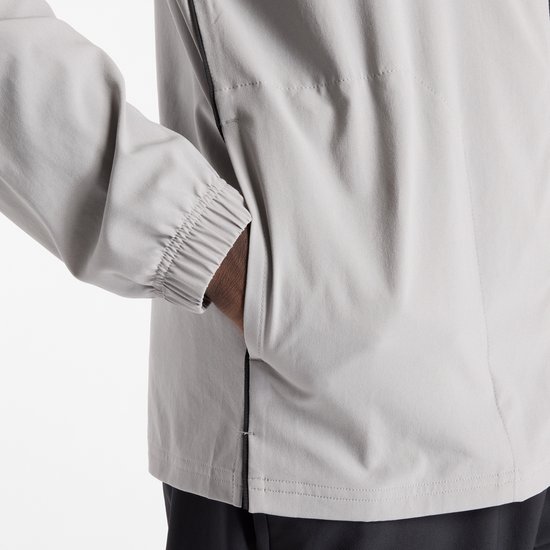 Detail van de grijze sportjas met zoom en elastische manchetten.