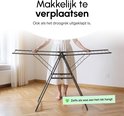 Een vrouw in een witte jurk verplaatst een zwart droogrek. Tekst: 'Makkelijk te verplaatsen', 'Ook als het droogrek uitgeklapt is' en 'Zelfs als was het rek hangt'.