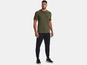 Man met donkergroen Under Armour sportshirt en zwarte joggingbroek.