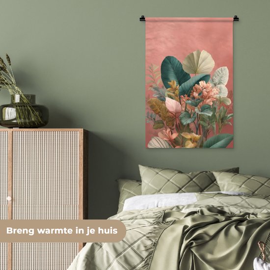 Een wandkleed met tropische bladeren in groen, crème en roze tinten, hangend in een slaapkamer met groene muren en beddengoed. Tekst: 'Breng warmte in je huis'.