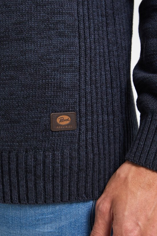Close-up van label op donkerblauwe gebreide trui.