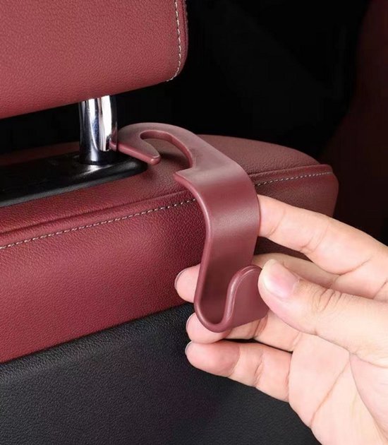 Bruin-rode autostoel hoofdsteunhaak met een gebogen ontwerp, in een hand.