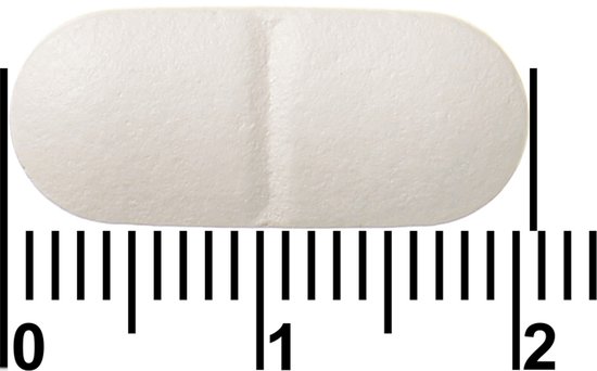 Close-up van een enkele witte Davitamon magnesium tablet met liniaal.