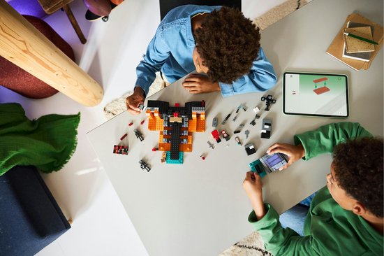 Deux garçons jouent avec des pièces LEGO Minecraft Wither Battle et une tablette d'instructions.