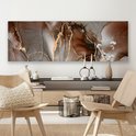 Abstract canvas met bruine, grijze en gouden marmerlook patronen, boven een houten dressoir.