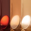 Drie stadia van de Philips wek-up light: van rood (06:35), naar zacht geel (06:45), naar helder wit (07:00).