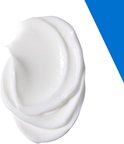 Een witte, romige crème op een witte achtergrond met een blauwe driehoekige vlek.