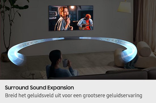 Abstracte blauwe geluidsgolven komen van een soundbar naar een vrouw die op de bank zit. Een tv toont een vrouw die zingt en een man die gitaar speelt.