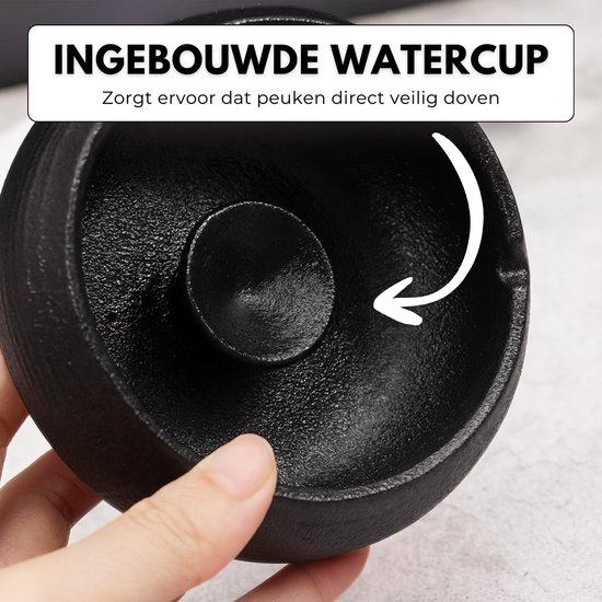 Binnenkant van zwarte keramische asbak met deksel, met pijl die naar de ingebouwde watercup wijst.