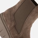 Detail van beige suède Chelsea laars met elastische zijkanten en stiksels.