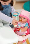 Meisje voert baby in roze bodysuit met beer motief eten.