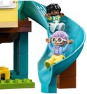 Twee LEGO Duplo poppetjes glijden van een blauwe glijbaan in een boomhut.